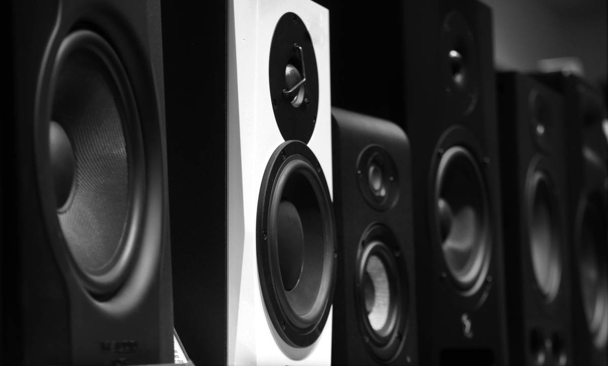 Comparison chart of common speaker driver types: woofer, tweeter, midrange with materials like paper, aluminum, silk, and their sound profiles
