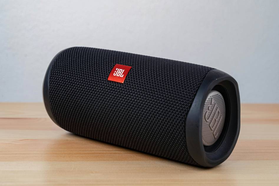 Modern smart speaker on wooden table with voice assistant interface glowing